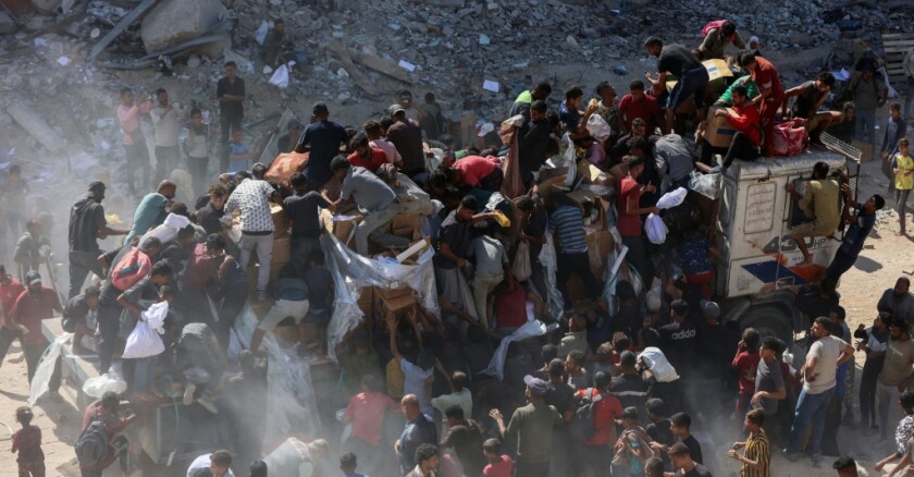 Des Palestiniens se précipitent sur un camion d'aide humanitaire à Khan Younès, dans le sud de la bande de Gaza, le 12 octobre 2025
